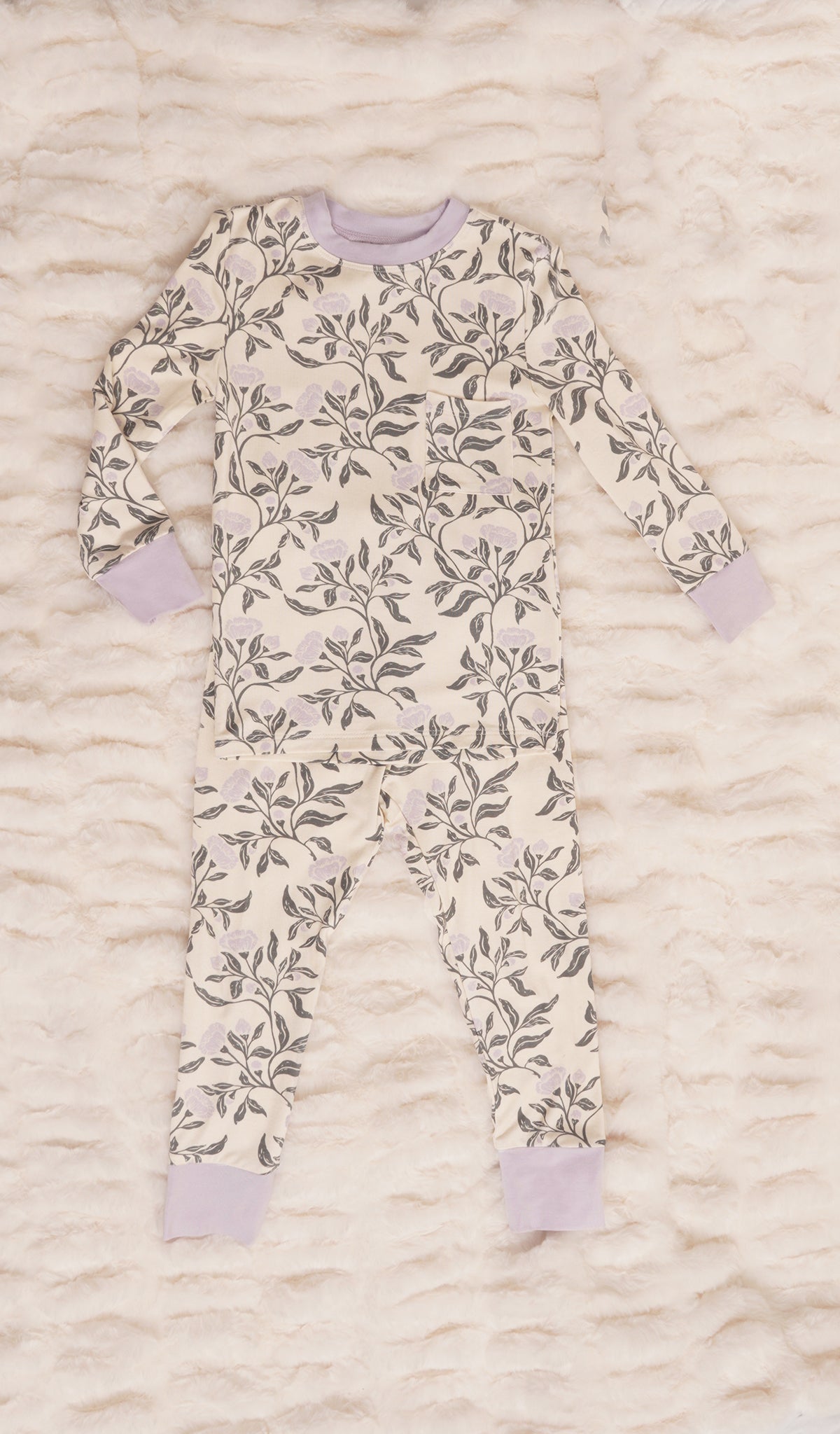 Poppy Emerson Kids 2-Piece Pant PJ. Long sleeve top with cuff trim and long pant with cuff trim on a textured beige blanket.