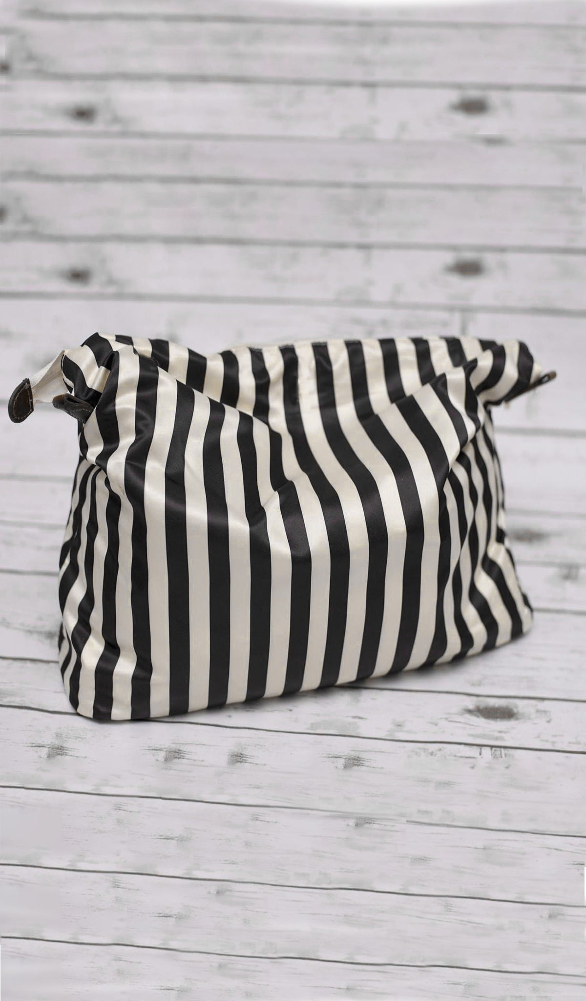 Caris Diaper Bag in black showing stripe drop in liner bag with zip closure.