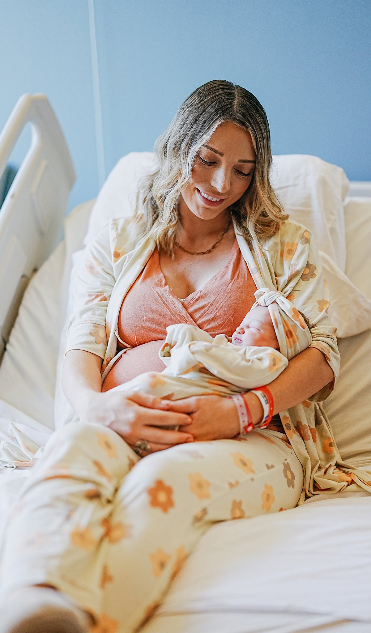 Daisies Analise 5-Piece Set worn by woman holding her newborn baby. Baby is wearing headwrap instead of baby hat.