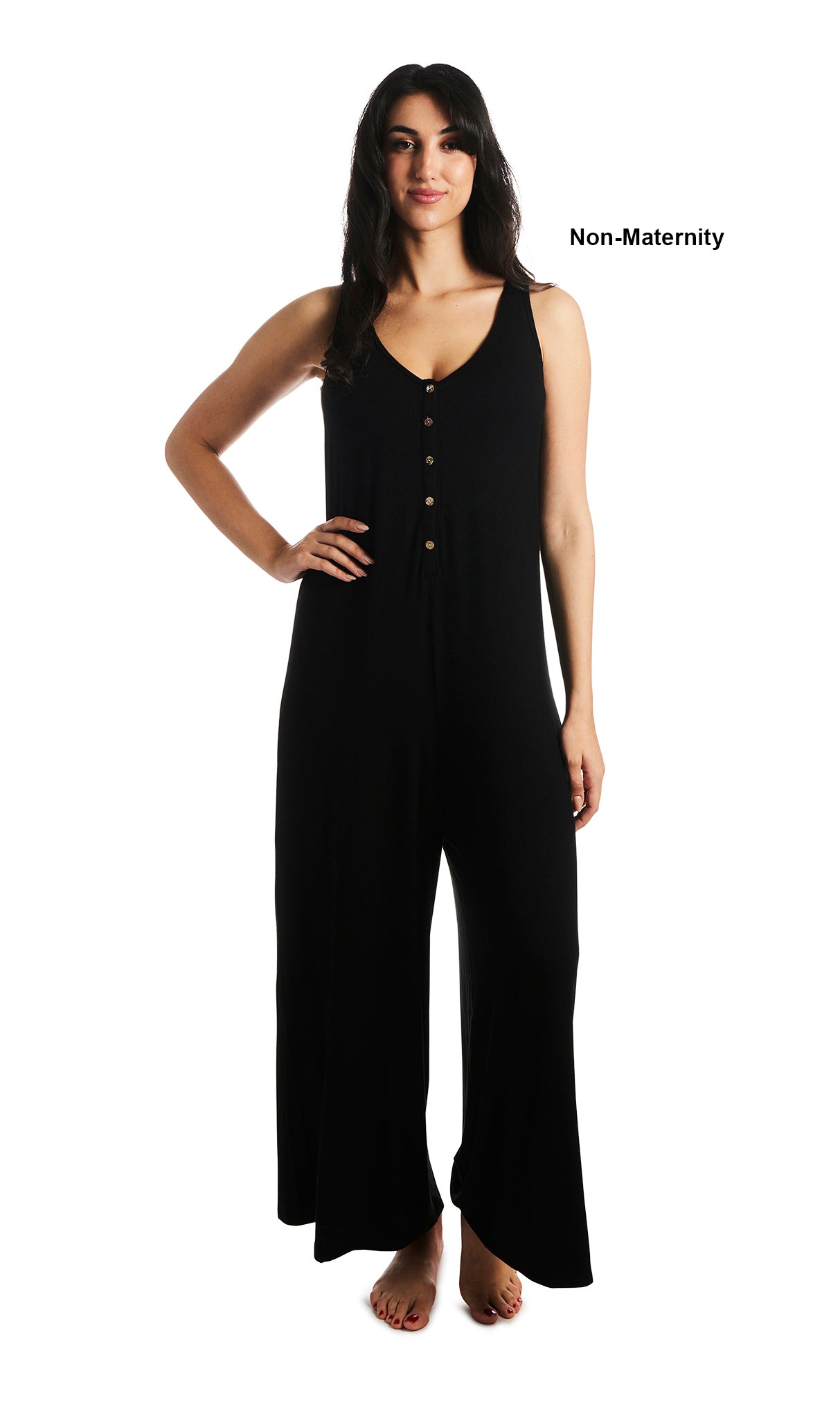 Black Luana romper. Woman wearing sleeveless wide-leg romper with scoop-neckline with button-front placket as non-maternity with one hand resting on hip.