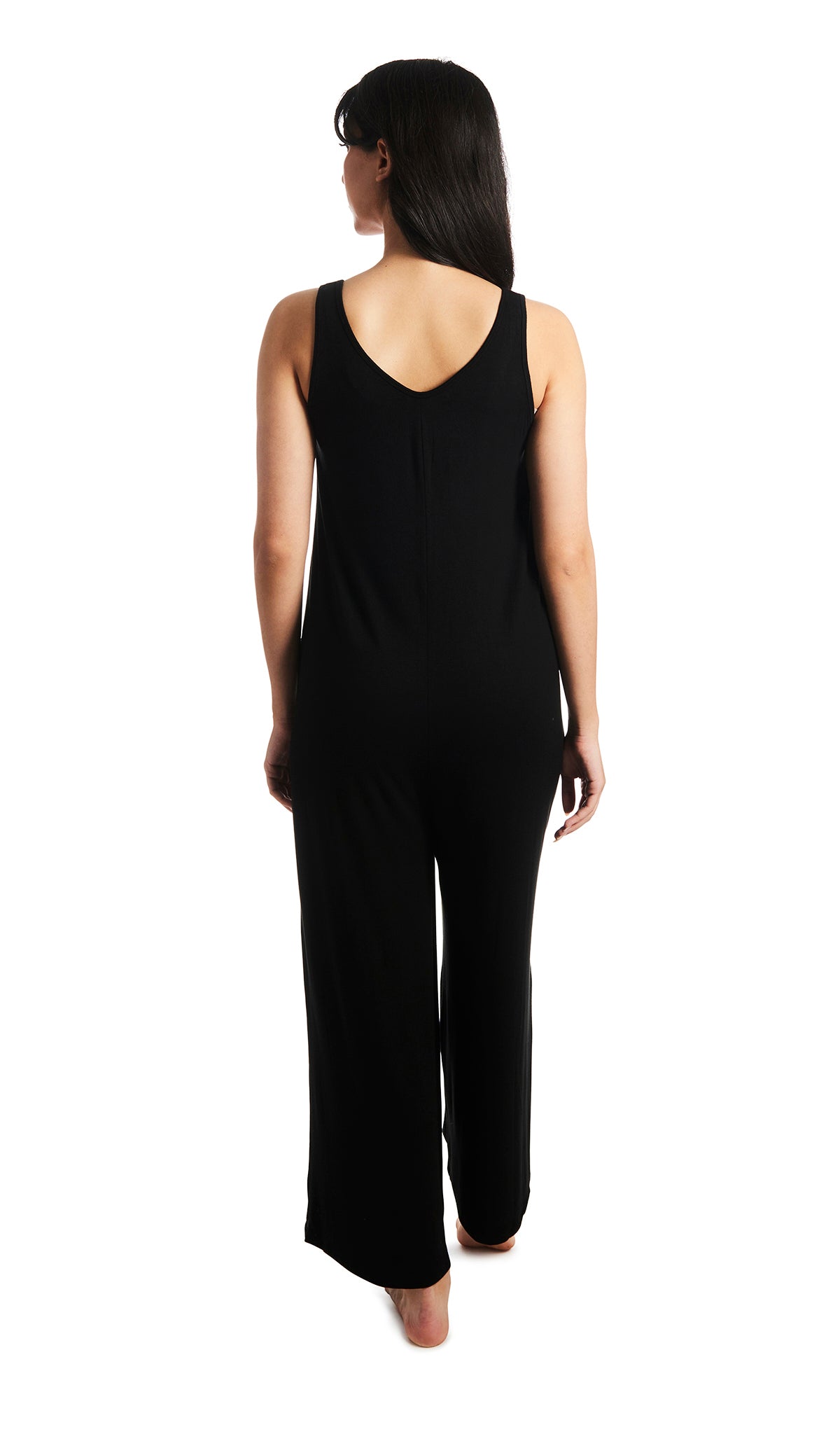 Black Luana romper. Back shot of woman wearing sleeveless wide-leg romper with arms down to side.