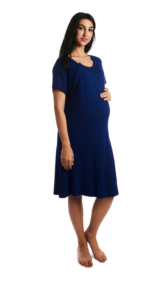 Denim Blue Rosa hospital gown. Pregnant woman with one hand on belly, wearing hospital gown with scoop-neckline featuring dual snap openings.