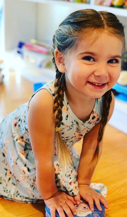 Cloud Blue Lucia Kids Twirly Dress. Little girl with big smile wearing Cloud Blue Lucia dress.