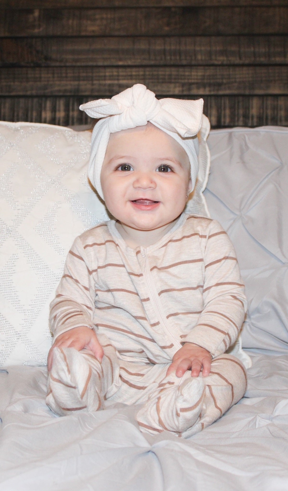Mocha Stripe Footie worn by baby with bow on her head.