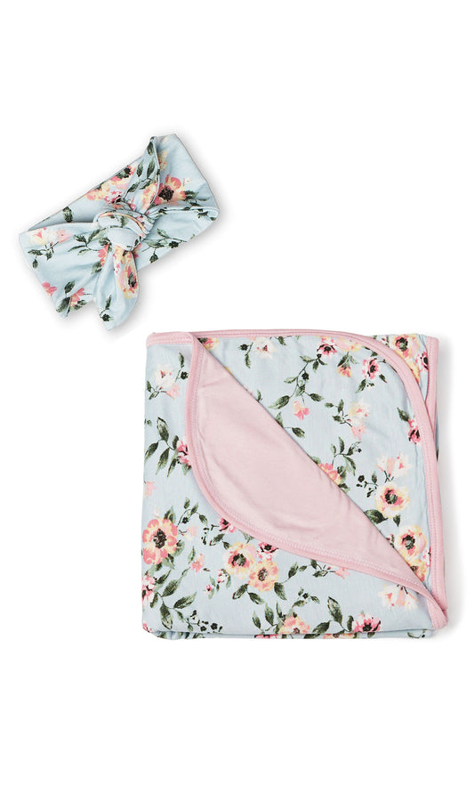 Swaddle & Headwrap Set - Cloud Blue. Flat shot of the floral blanket folded and laying next to headwrap in matching print.