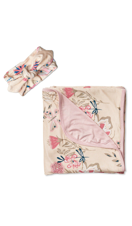 Swaddle & Headwrap Set - Wild Flower. Flat shot of the floral blanket folded and laying next to headwrap in matching print.