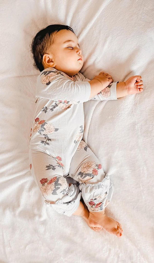 Peony Ruffle Romper 2-Piece worn by sleeping baby girl.