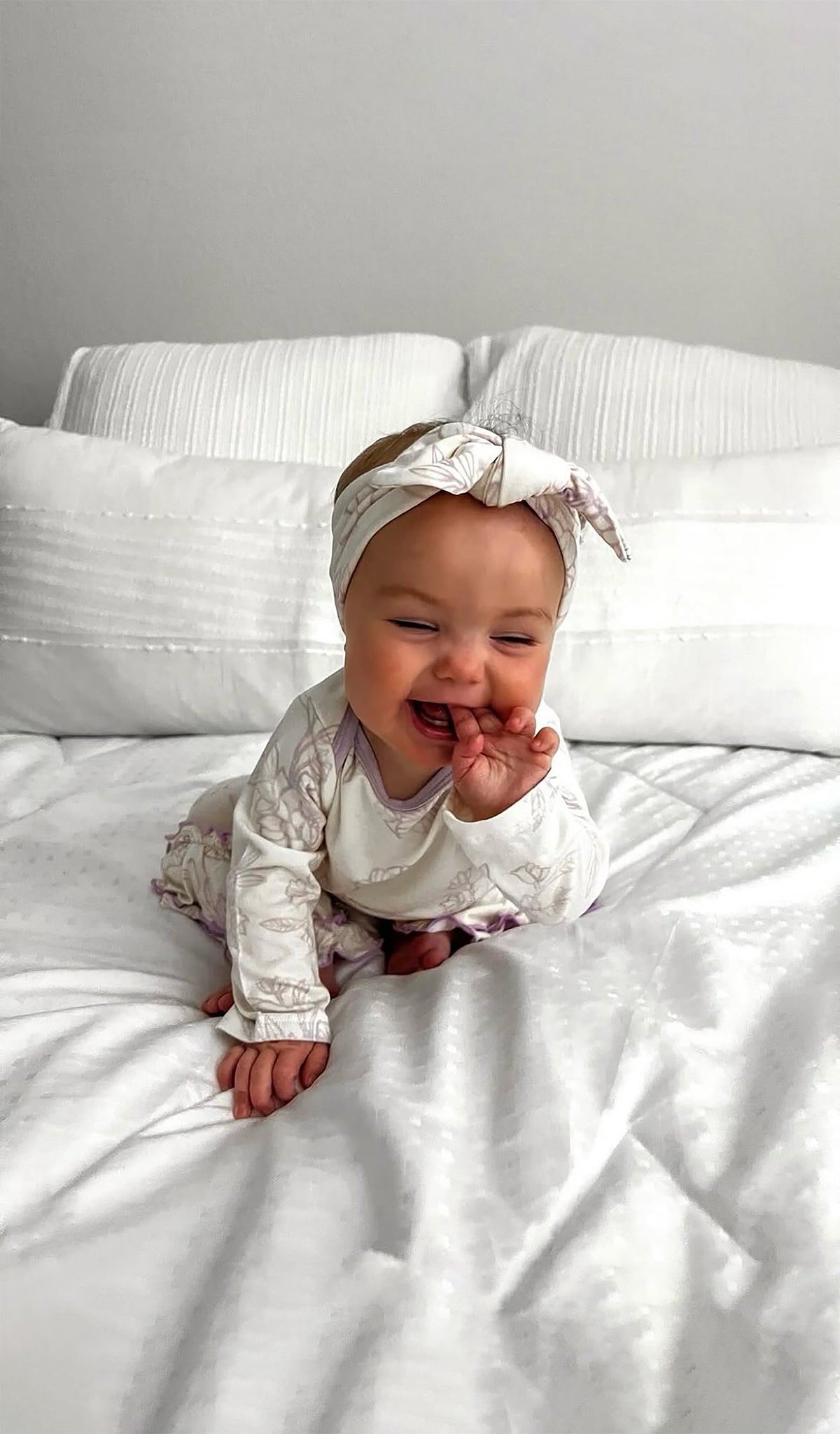 Bali Baby/Kids Headwrap worn by baby girl sitting on a bed.