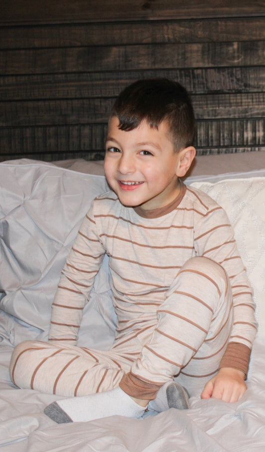 Mocha Stripe Emerson Kids 2-Piece Pant PJ worn by little boy sitting on his bed.