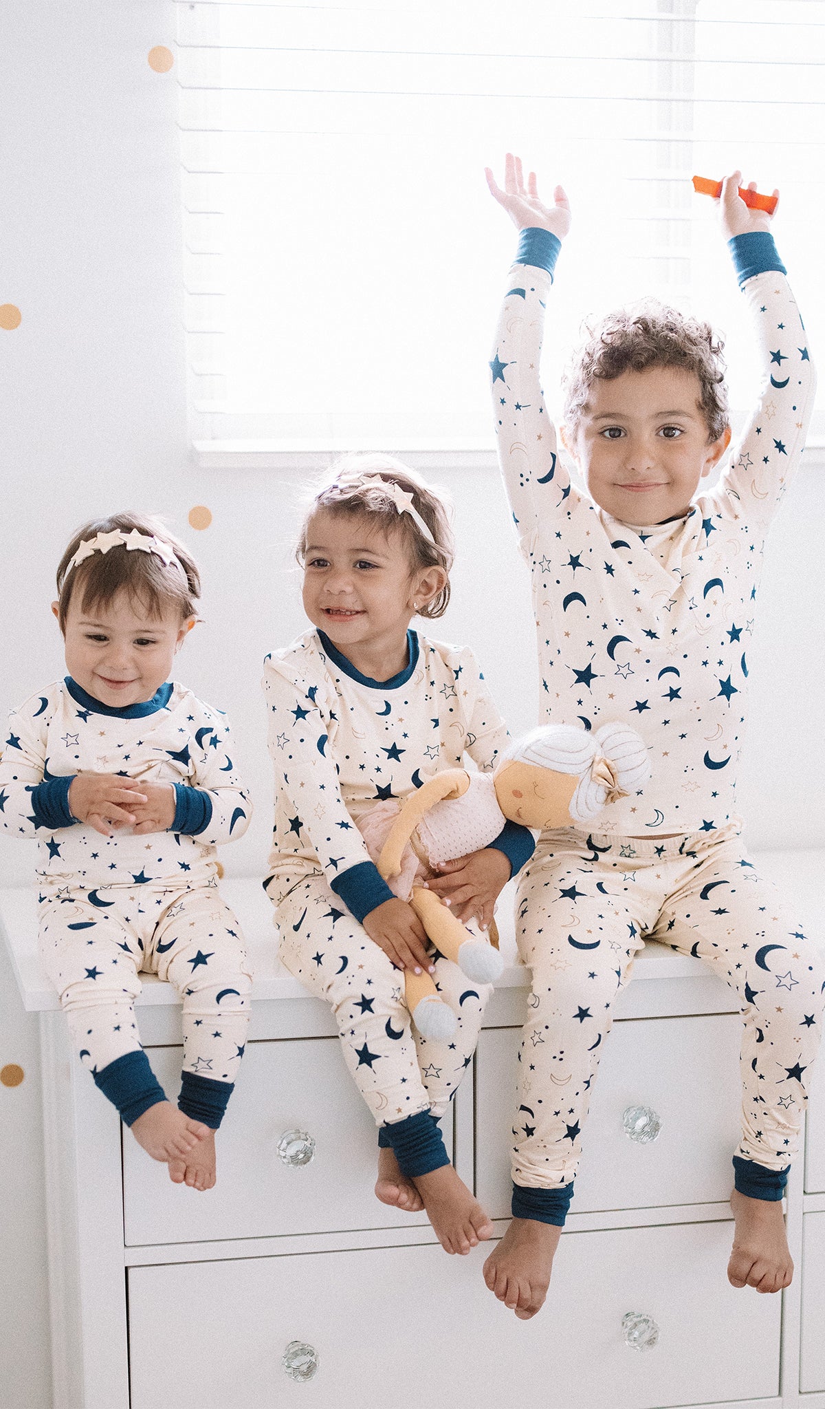 Twinkle Emerson Baby 2-Piece Pant PJ worn by baby girl sitting next to her big sister and brother in matching PJs.