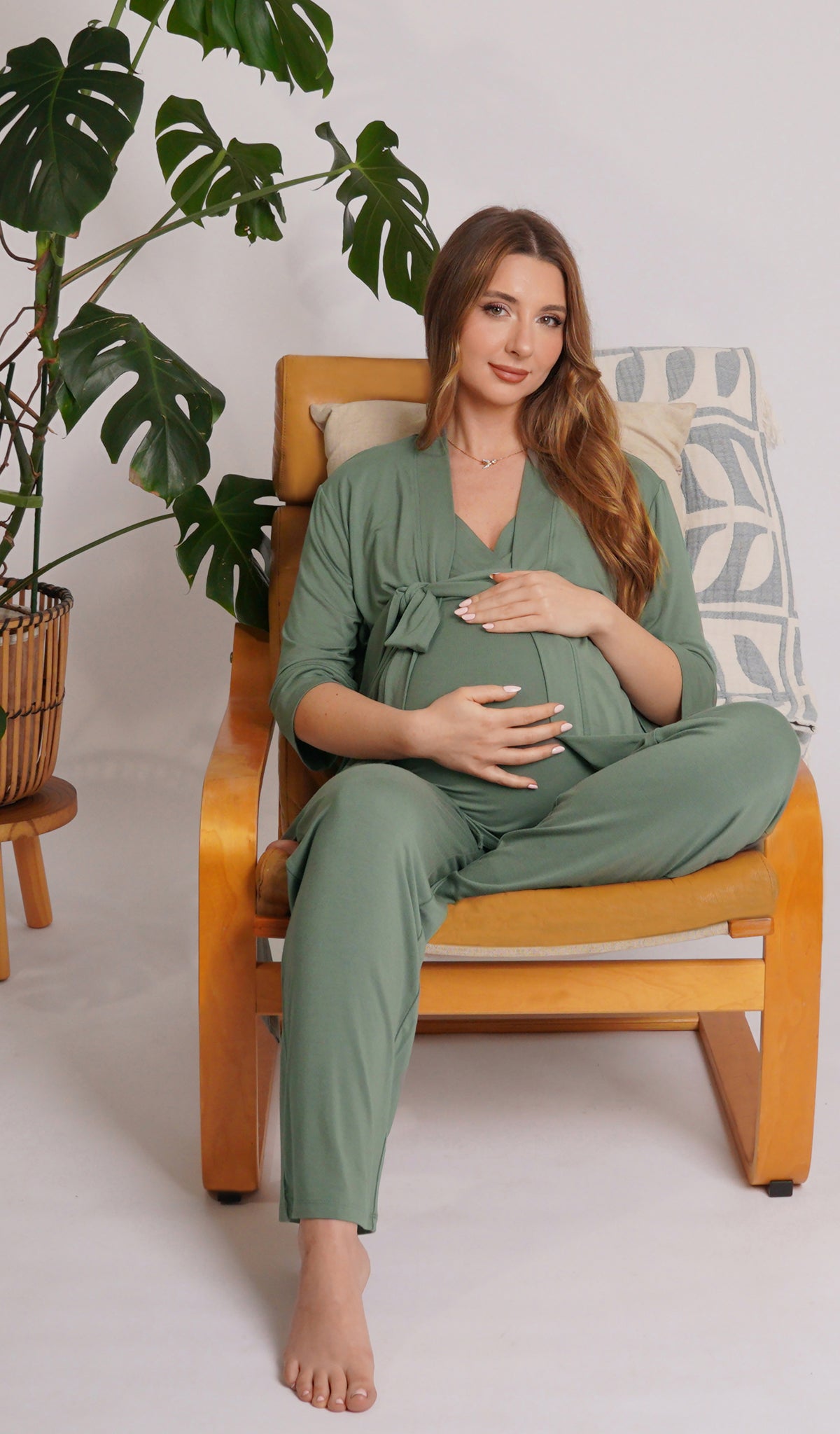 Basil Analise 3-Piece Set worn by pregnant woman sitting with one leg underneath her on chair with hands on belly.