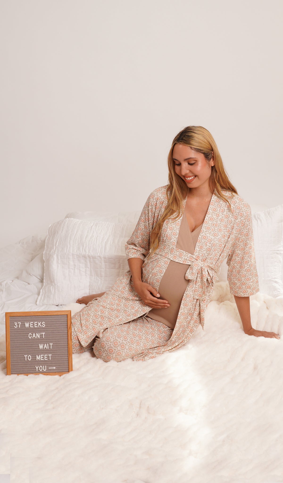 Bohemian Analise 3-Piece Set, woman wearing robe, tank top and pant sitting on bed leaning back on one hand while holding belly with other hand with a 37 weeks can't wait to meet you sign.