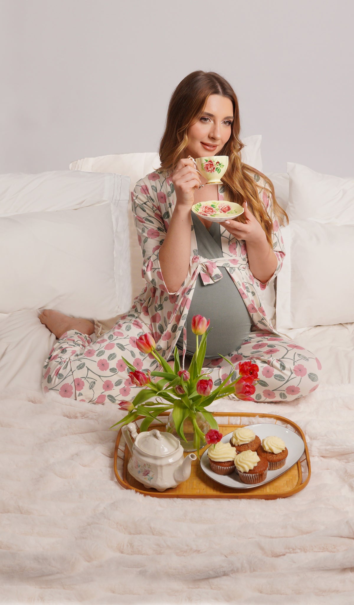 Honey Bloom Analise 5-Piece Set, woman wearing robe, tank top and pant while sitting on a bed drinking tea with muffins.
