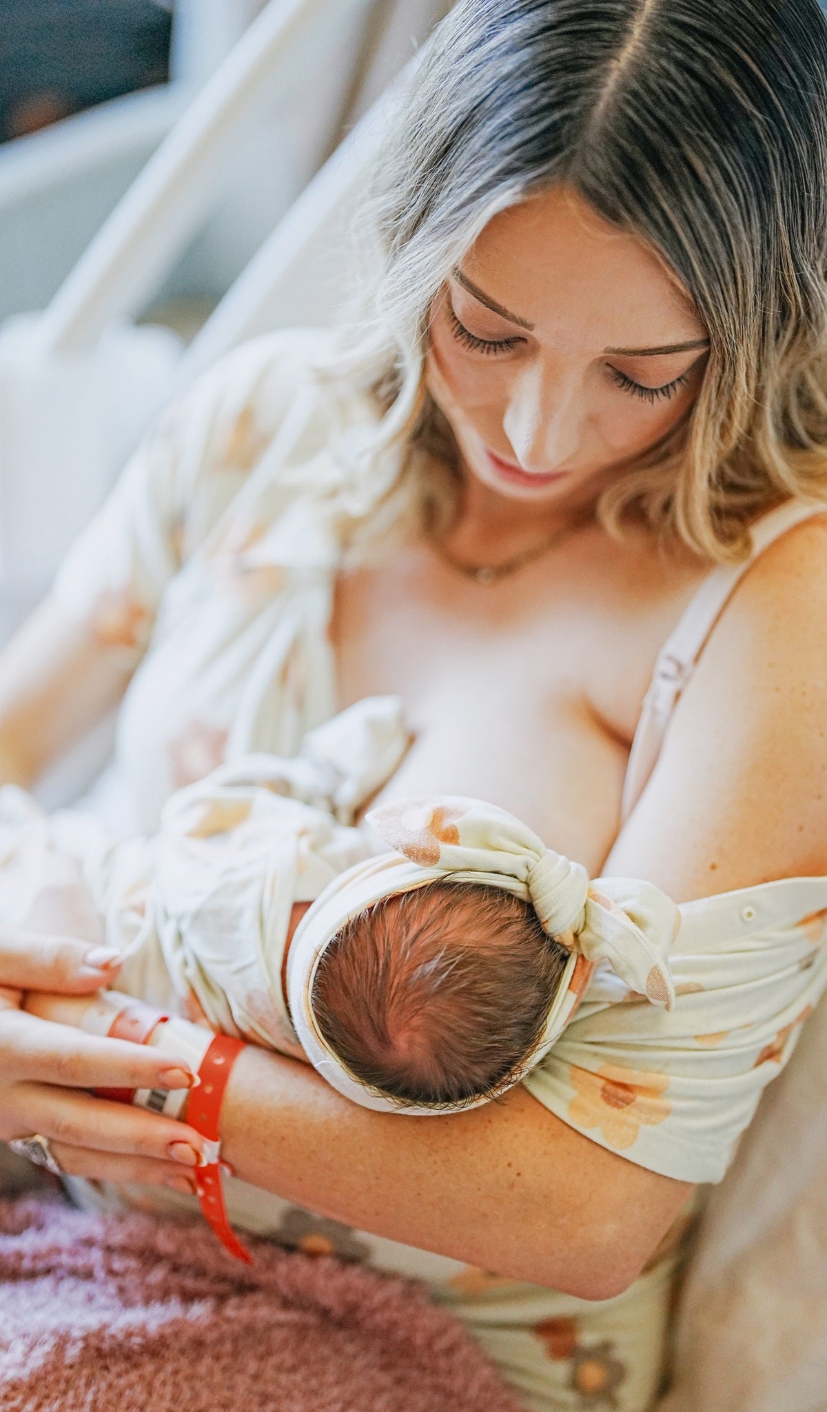 Daisies Rosa hospital gown worn by woman breastfeeding her newborn baby.