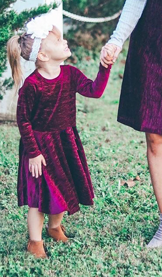 Merlot Kendyl Kids Twirly Dress. Little girl wearing Kendyl long sleeve dress, holding hands with woman wearing matching Aurora Merlot dress.