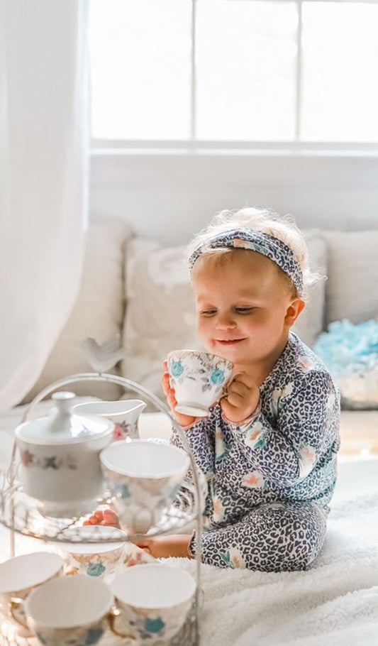 Jungle Floral Charlie Kids 3-Piece Pant PJ. Little girl sitting and wearing Charlie 3-Piece PJ set while holding a teacup with both hands.