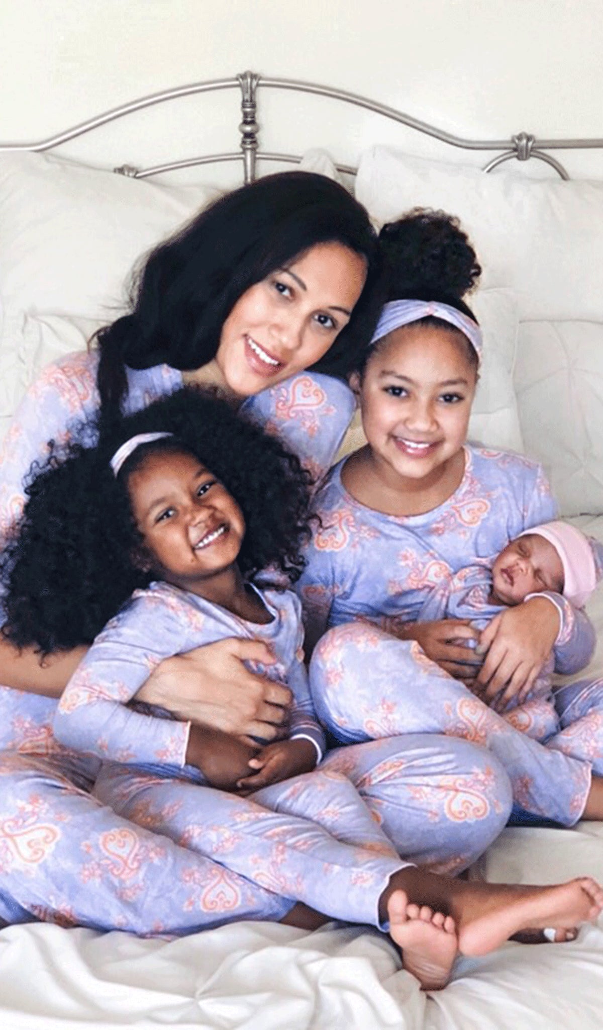 Boho Charlie Kids 3-Piece Pant PJ. Older girl and little girl both wearing Charlie long sleeve top, pant and matching headwrap holding baby sister in matching baby gown with knotted hat and sitting with mom wearing matching robe and pant from Analise PJ set.