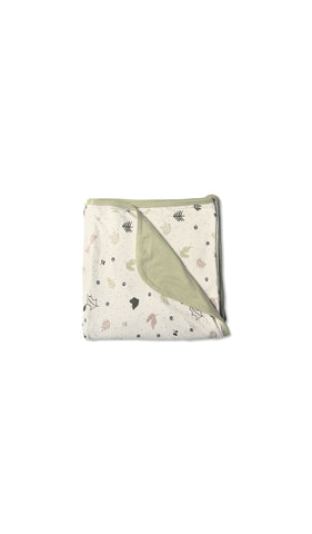 Nature Swaddle Blanket folded into a square with print showing on one side and reversible contrast solid showing on other side of fold down flap.