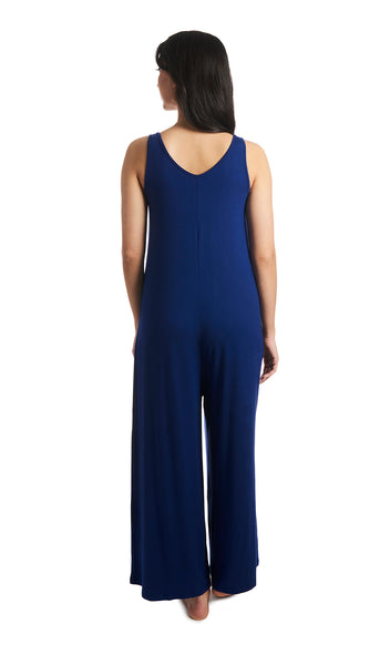 Denim Blue Luana romper. Back shot of woman wearing sleeveless wide-leg romper with arms down to side.