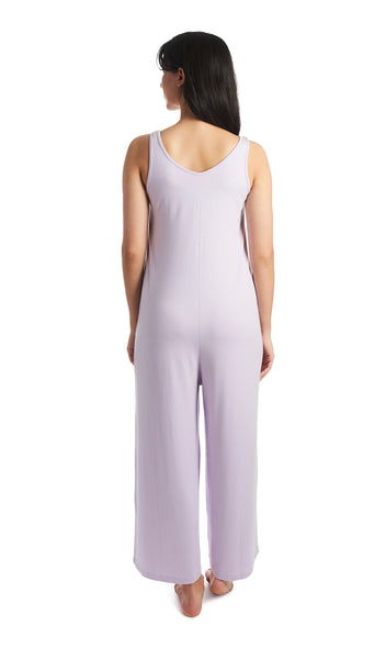 Lavender Luana romper. Back shot of woman wearing sleeveless wide-leg romper with arms down to side.