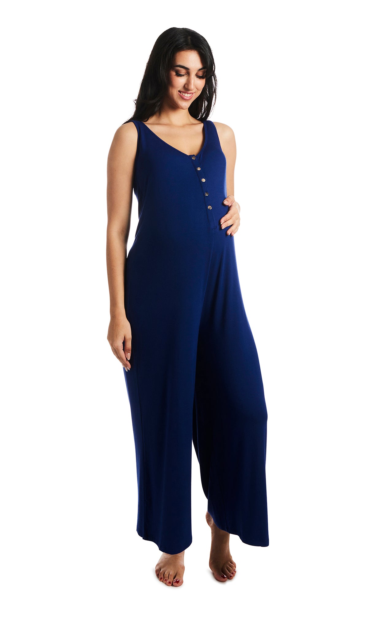Denim Blue Luana romper. Pregnant woman looking down with one hand on belly, wearing sleeveless wide-leg romper with scoop-neckline with button-front placket. 