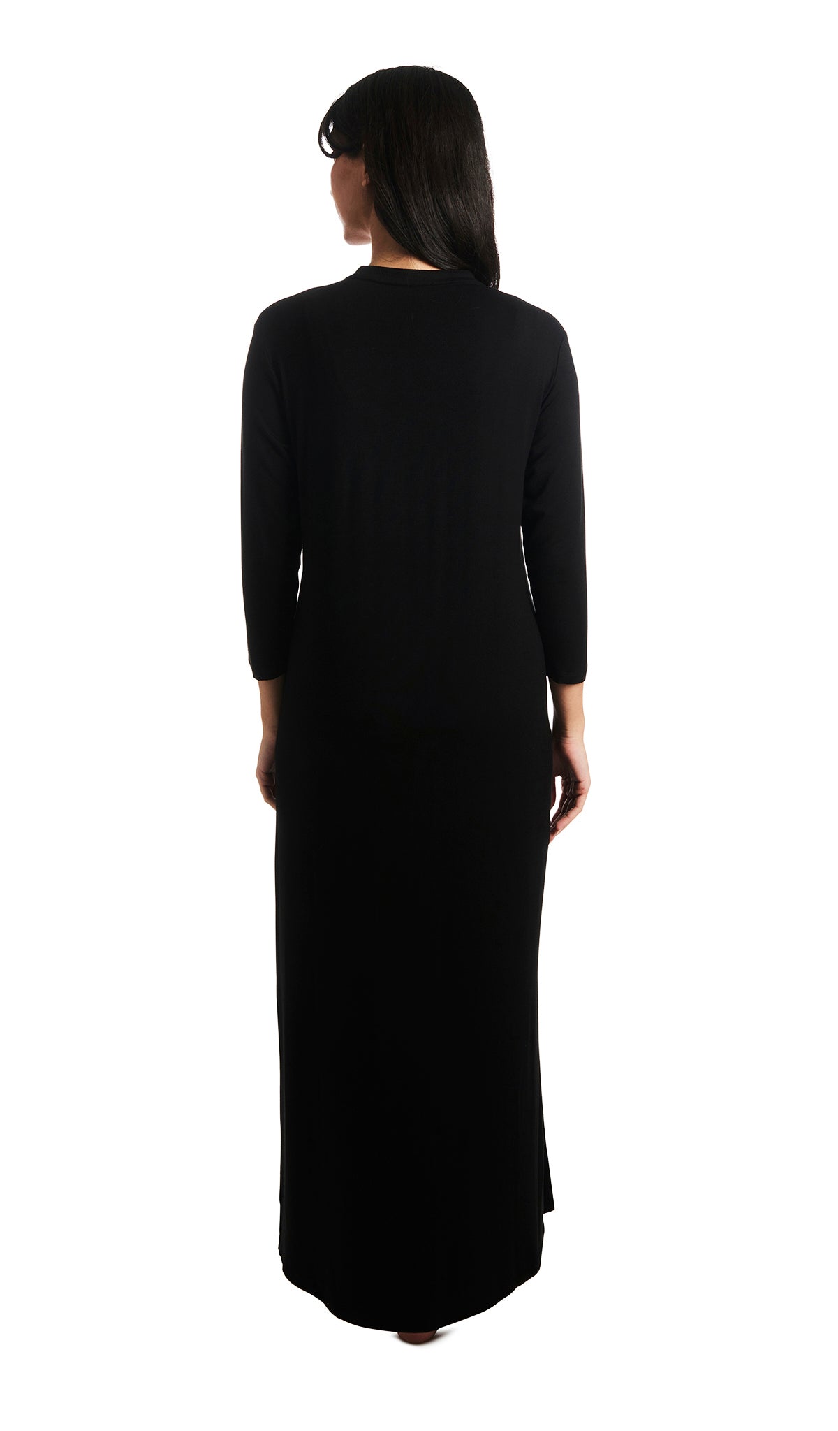 Black Juliana dress. Back shot of woman wearing long sleeve caftan with arms down to side.