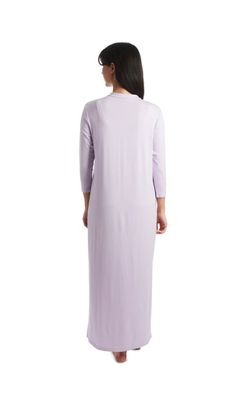 Lavender Juliana dress. Back shot of woman wearing long sleeve caftan with arms down to side.
