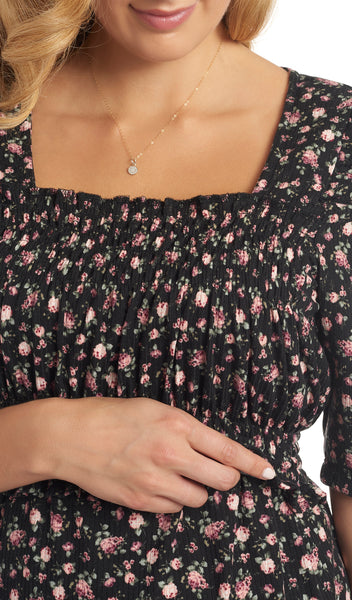 Black Floral Tracey detail shot of woman lifting ruffle layer to access nursing openings underneath.