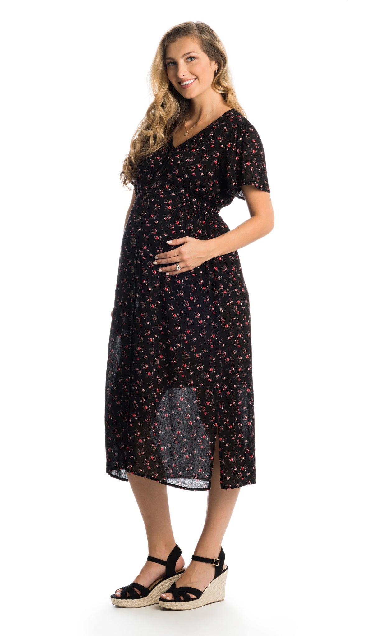 Black Floral Ballencia dress worn by pregnant woman with one hand on belly.