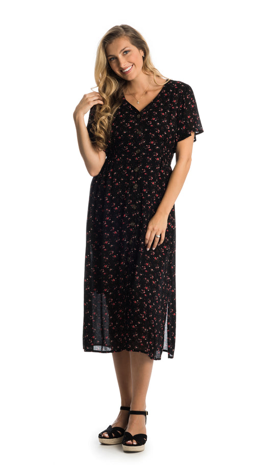 Black Floral Ballencia dress worn by woman touching her hair with one hand and worn as non-maternity style.