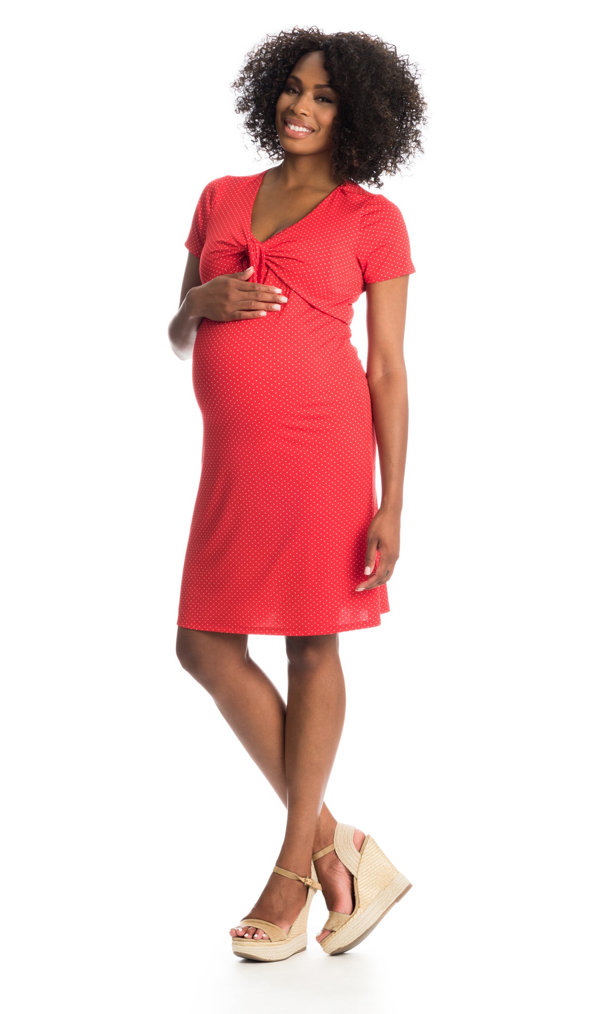 Red Dot Jada dress worn by pregnant woman with one hand on her belly.