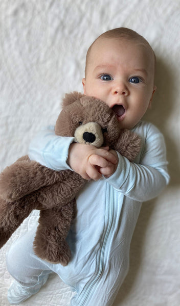 Whispering Blue Footie 2-Piece worn by baby holding teddy bear.