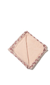 Pink Blush Swaddle Blanket folded into a square with reversible contrast solid showing.