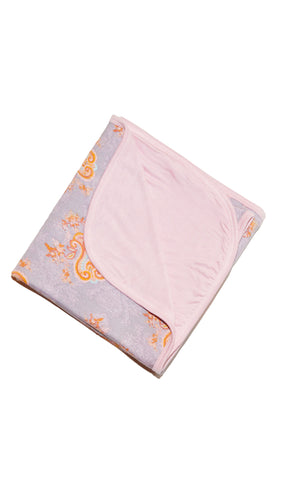 Boho Swaddle Blanket folded into a square with print showing on one side and reversible contrast solid showing on other side of fold down flap.