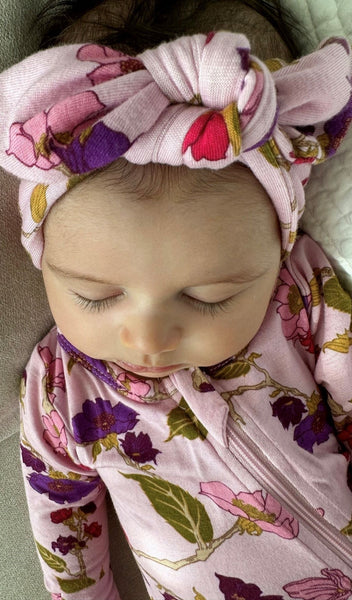 Lavender Rose Footie 2-Piece Set. Sleeping baby wearing zip front footie with matching headwrap tied into a tie-knot bow.