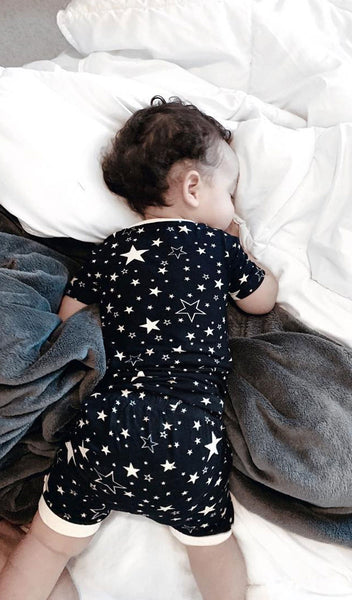 Stars Aydenne Baby 2-Piece Short PJ. Lifestyle shot of boy sleeping on his stomach in bed wearing Aydenne.