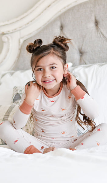 Sunrise Emerson Kids 2-Piece Pant PJ worn by girl sitting on her bed.