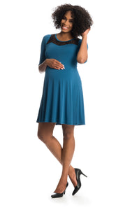 Cerulean Pipa dress worn by pregnant woman with one hand on her belly.