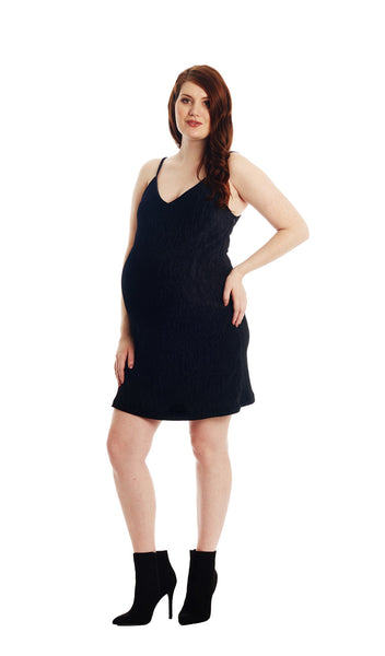 Black Aurora dress worn by pregnant woman with one hand on her hip.