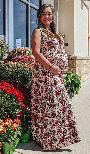 Amaryllis Valeria dress worn by pregnant woman standing outside near plants.