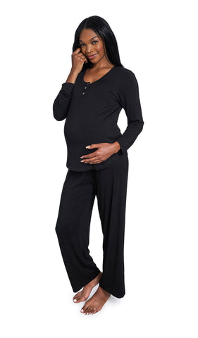 Black Laina 2-Piece Set. Pregnant woman wearing button front placket long sleeve top and pant with one hand holding belly and other hand touching side of face.