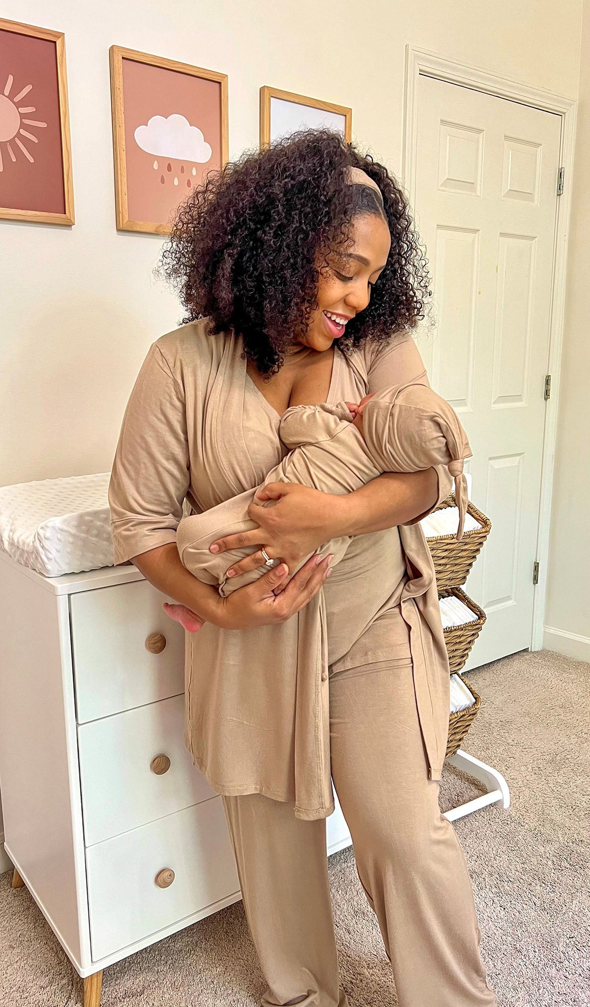 Latte Analise 5-Piece Set. Woman wearing 3/4 sleeve robe, tank top and pant while holding a baby wearing baby gown and knotted baby hat.