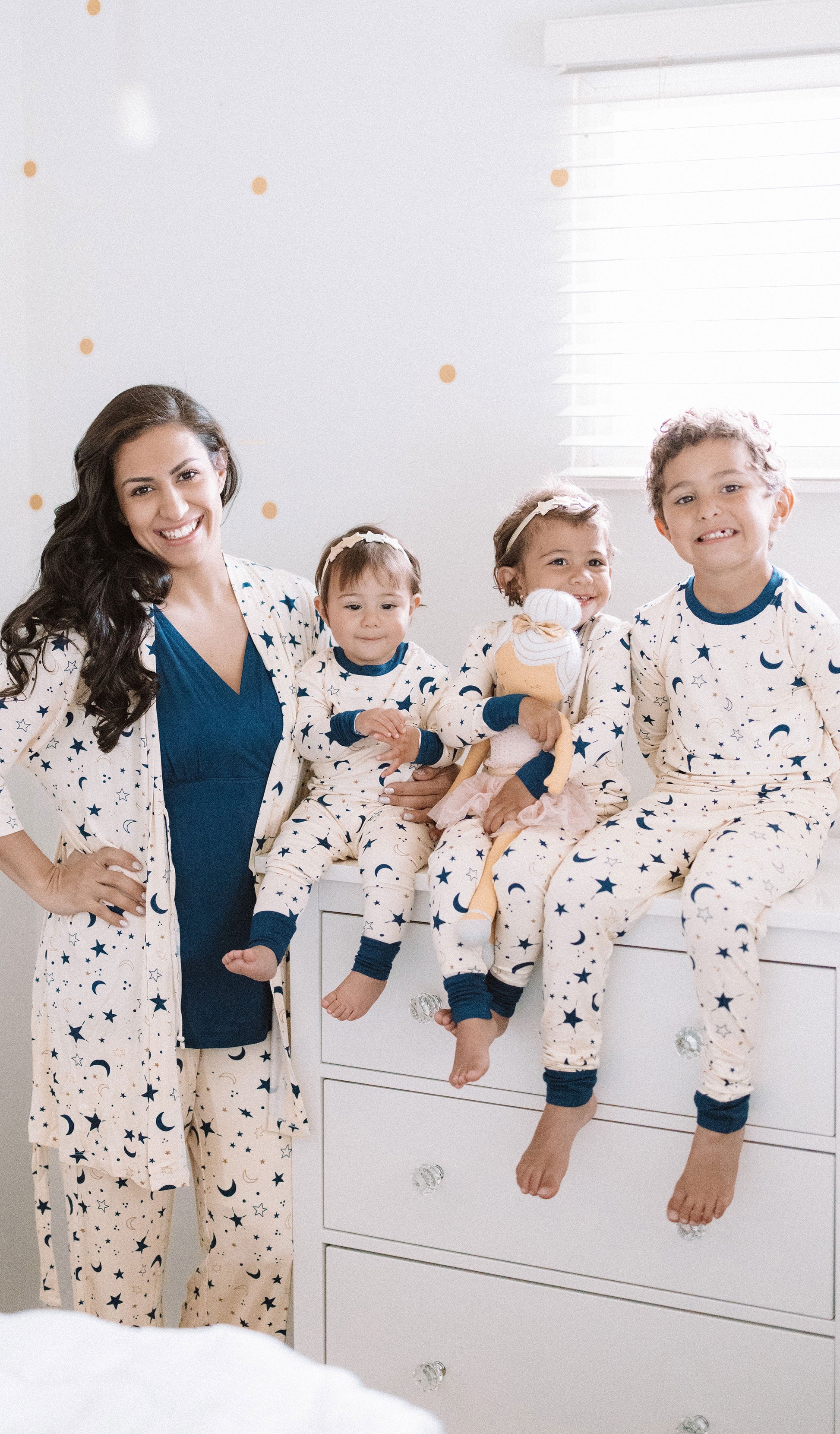 Twinkle Analise 3-Piece Set, woman standing wearing robe, tank top and pant next to 1 boy and 2 girls sitting together in matching Emerson pajama sets.