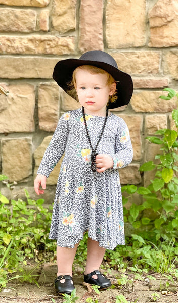 Jungle Floral Kendyl Kids Twirly Dress. Little girl outdoors wearing Kendyl long sleeve dress with twirly skirt with black hat.
