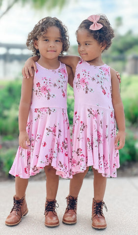 Blossom Lucia Kids Twirly Dress. Two little girls wearing matching Blossom Lucia dresses with their arms around each other.