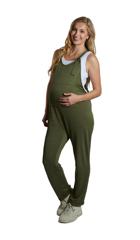 French Terry Olive Natalie Overall. Pregnant woman wearing short sleeve tee shirt under Natalie overall with one hand in front kangaroo pocket.