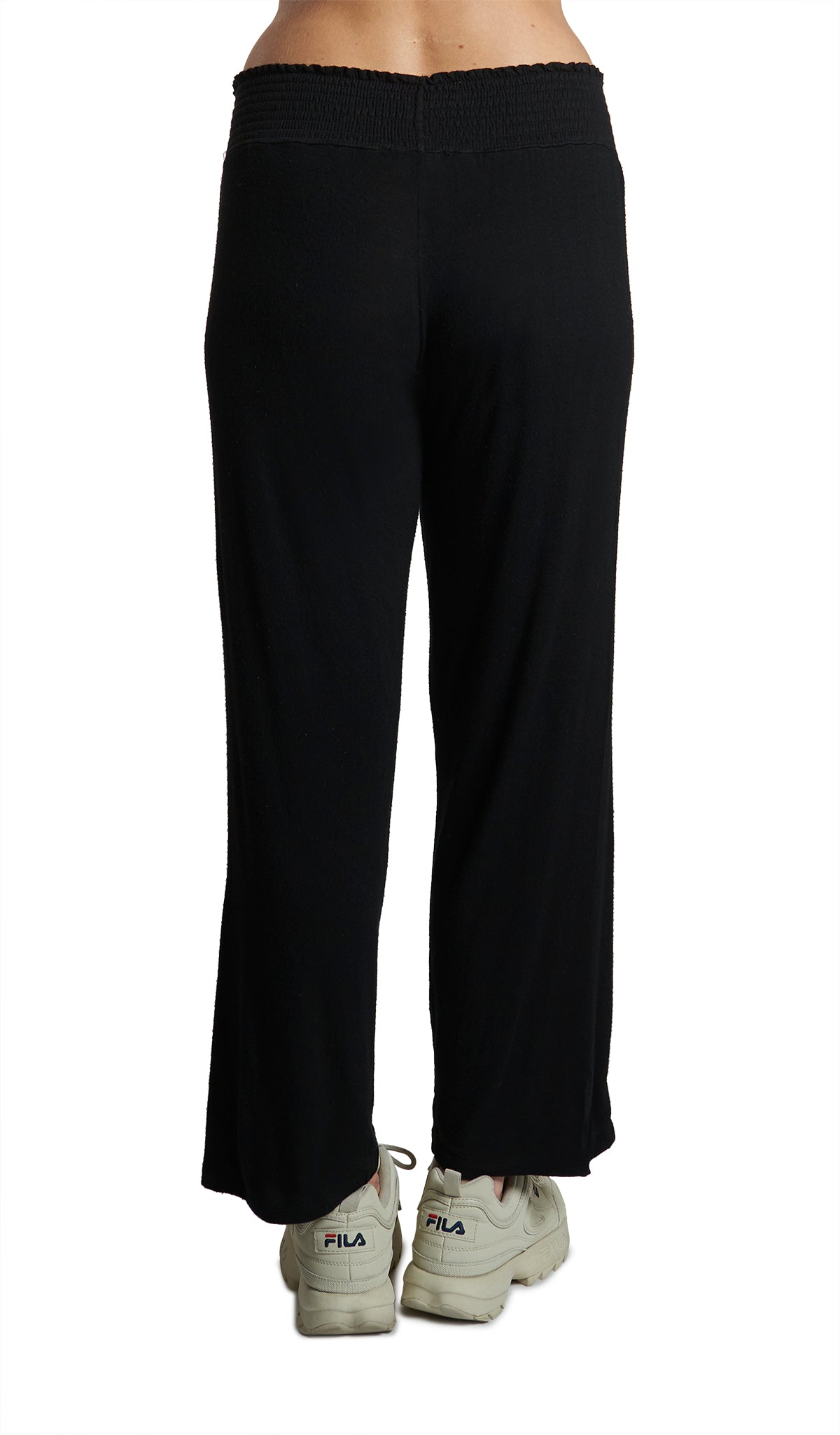 Black Pirlo Pant. Back shot of pirlo pant shown waist down on woman wearing with tennis shoes.