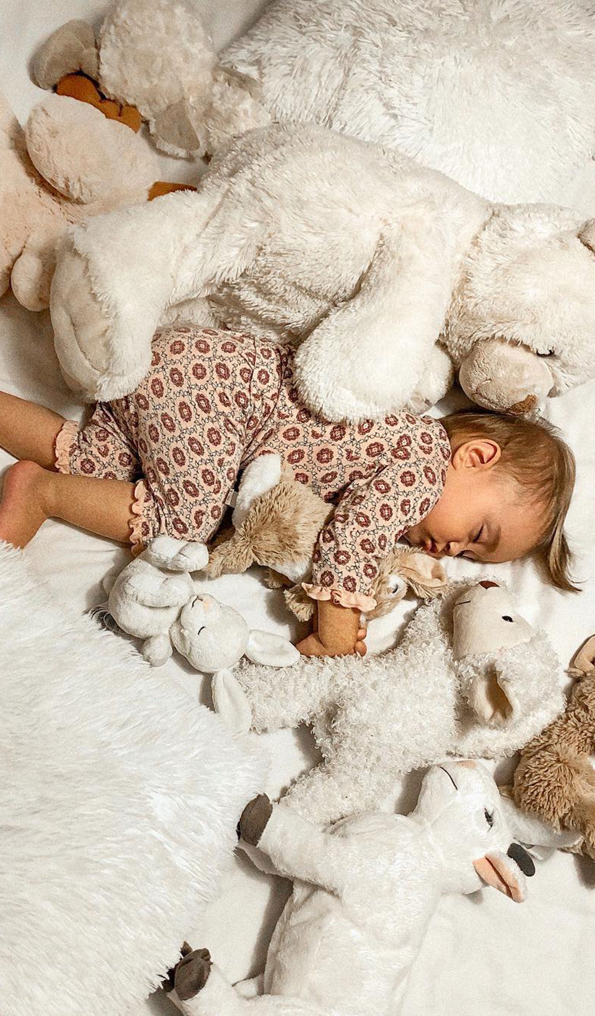 Baby's Ruffle Take-Me-Home 3 Piece - Pink Blush worn by sleeping baby next to several stuffed animals.