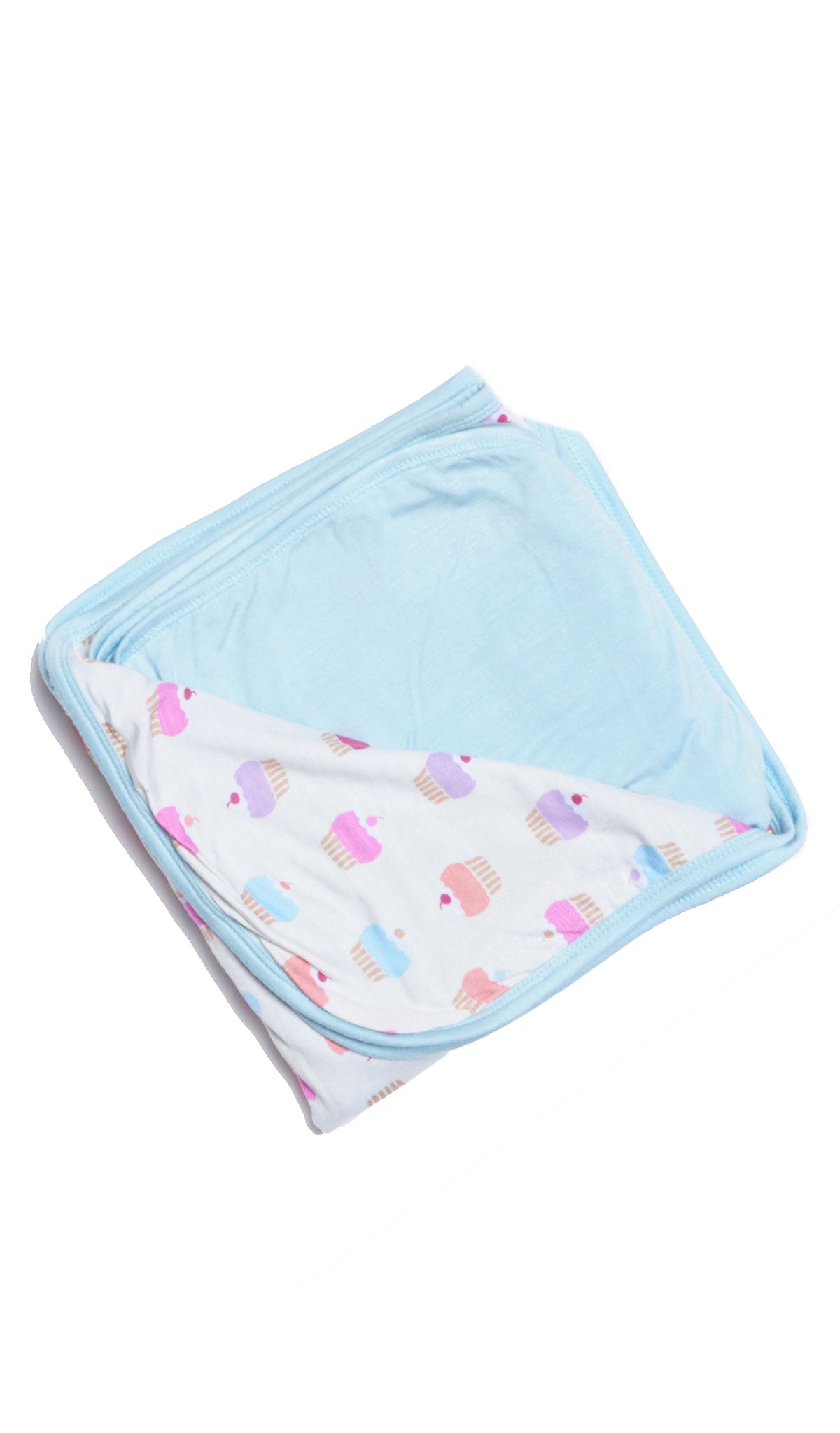 Cupcakes Swaddle Blanket folded into a square with print showing on one side and reversible contrast solid showing on other side of fold down flap.