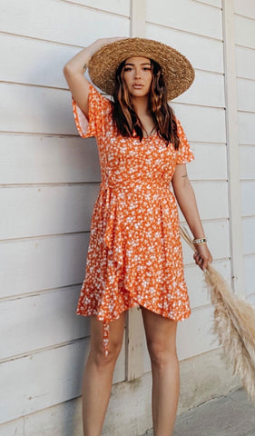 Citrus Floral Kristi Dress worn by woman wearing hat with one hand on her head.